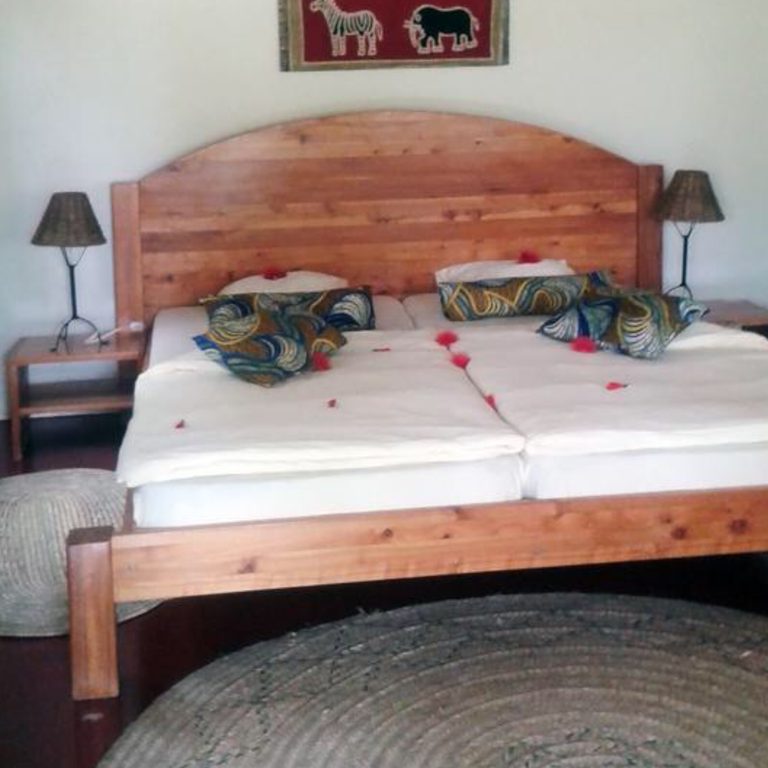 A Standard Simba room with a carved wooden bed